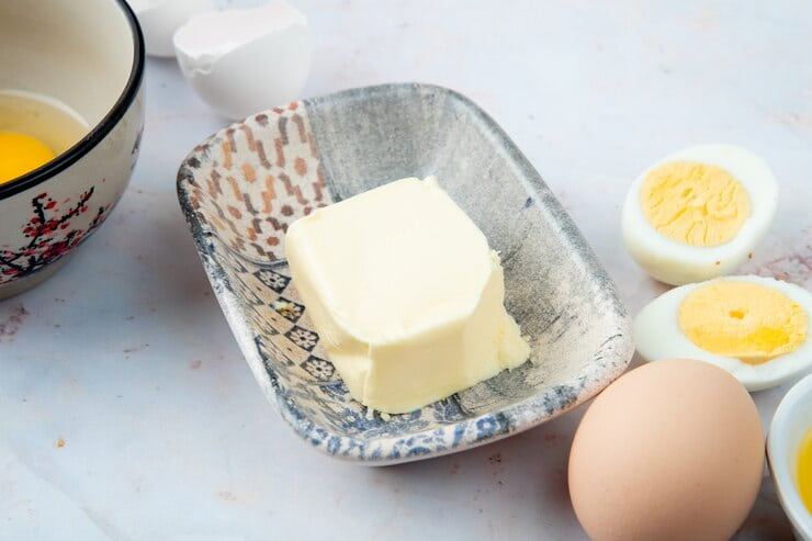 close-up-view-plate-butter-with-eggs-white-background_141793-2551 (1)